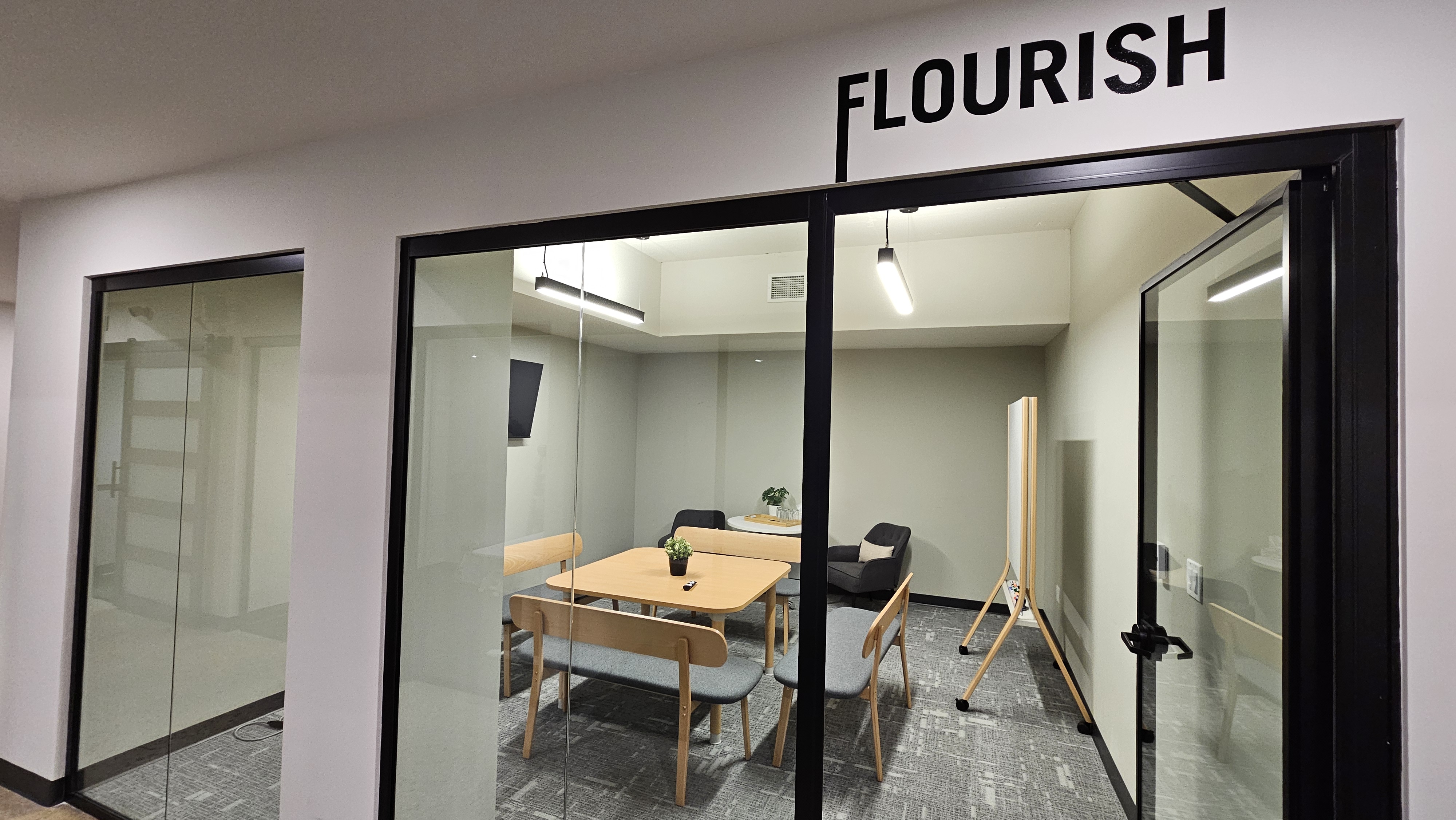 A meeting room equipped with a table, seating for six and 50" TV.